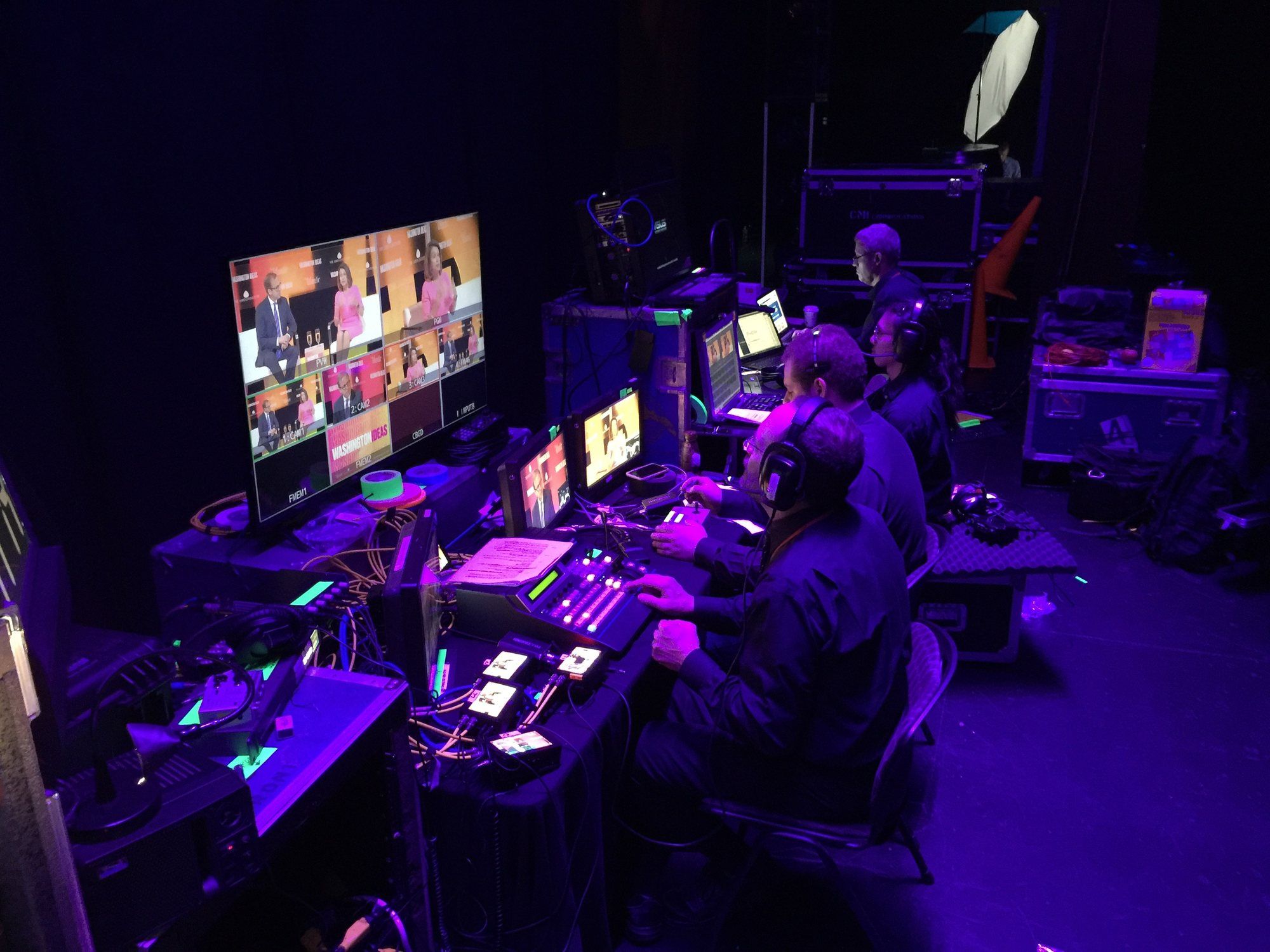 The Astrocasters video team running a live stream backstage at the Washington Ideas Forum, now the Atlantic Festival: operators at switchers under purple light.