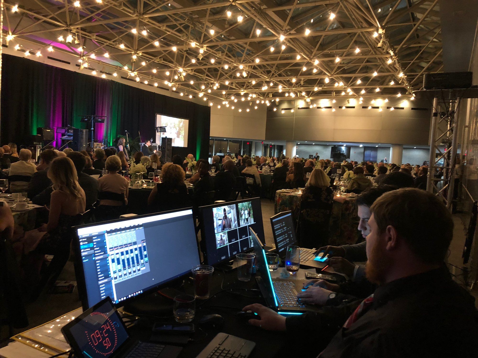 Astrocasters operators running video and presentations from the back of a gala ballroom.